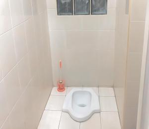 - une salle de bains blanche avec toilettes dans une cabine dans l'établissement Homestay Levida Mitra RedDoorz, à Samarinda