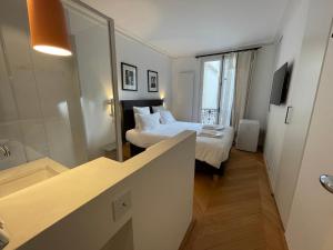 una camera d'albergo con due letti e un bagno di RESIDENCES HARCOURT - Ile Saint Louis - PARIS a Parigi