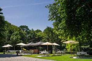 un gruppo di tavoli con ombrelloni in un parco di Kasteel de Wittenburg a Wassenaar