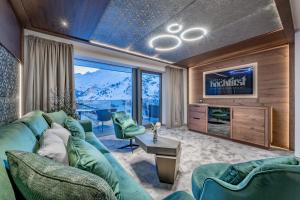 a living room with a blue couch and a television at Alpen-Wellness Resort Hochfirst in Obergurgl