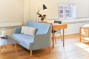 ein Wohnzimmer mit einem blauen Stuhl und einem Schreibtisch in der Unterkunft Pierspeicher Boardinghouse in Kappeln