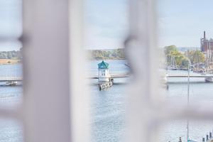 Blick auf einen Fluss mit einem Leuchtturm im Wasser in der Unterkunft Pierspeicher Boardinghouse in Kappeln