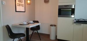 a small kitchen with a small table and a refrigerator at Zeehuis Zandvoort in Zandvoort