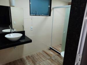 bagno con lavandino e doccia in vetro di Alice Suites ad Arraial do Cabo