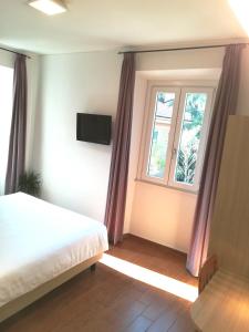 a bedroom with a bed and a window at Hotel Quarcino in Como