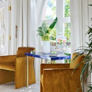 a blue table in a room with chairs and a window at The Beverly Hills Hotel - Dorchester Collection in Los Angeles