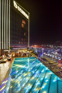 una piscina di fronte a un edificio di notte di Zhuhai Longzhuda International Hotel a Zhuhai