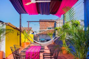 een hangmat op een balkon met stoelen en planten bij CASA MARÍA MALECÓN in Puerto Vallarta