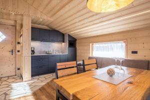 una cucina e una sala da pranzo con tavolo in legno di Chalet Henne- Hochgruberhof a Selva dei Molini