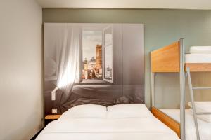 a bedroom with two beds and a window at B&B HOTEL Louveciennes in Louveciennes