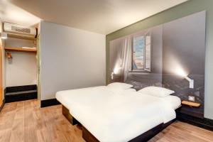 a bedroom with two beds and a window at B&B HOTEL Louveciennes in Louveciennes