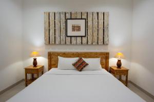 A bed or beds in a room at Bali Komang Guest House Sanur