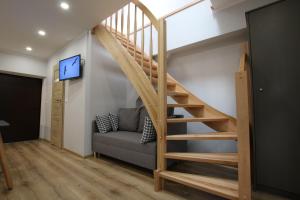 a staircase in a room with a couch and a tv at Auto-Camping Park in Jelenia Góra