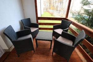 a balcony with four chairs and a window at Auto-Camping Park in Jelenia Góra