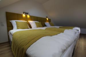 two beds with green and white sheets in a room at Auto-Camping Park in Jelenia Góra