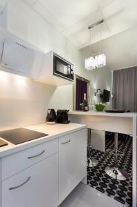 - une cuisine avec des placards blancs et un sol noir et blanc dans l'établissement Apartamenty Vola Residence, à Varsovie