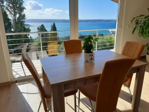 tavolo da pranzo con sedie e vista sull'oceano di Red Rose Apartment a Portoroz