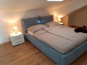 una camera con letto blu e 2 lampade su comodino di Red Rose Apartment a Portoroz