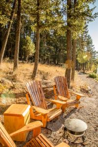 duas cadeiras de madeira e uma mesa na floresta em Gateway Motel em Radium Hot Springs