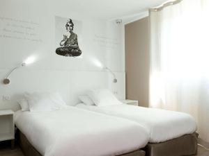 1 dormitorio con 2 camas y un cartel de meditación en la pared en ibis Styles Rennes St. Gregoire, en Saint-Grégoire