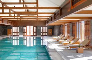 una piscina con sedie a sdraio e una piscina di Jinmao Purelax Lijiang, The Unbound Collection By HYATT a Lijiang