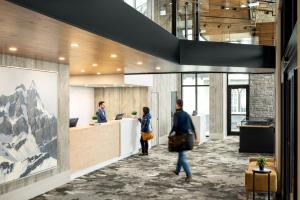 a lobby with people standing at a counter at Peaks Hotel and Suites in Banff