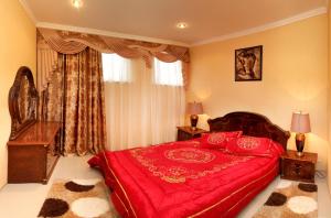 a bedroom with a red bed with red pillows at Гранд Алексік in Truskavets