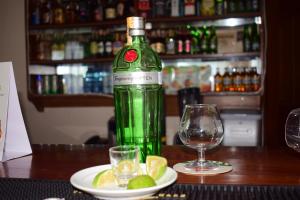 eine grüne Flasche Wein neben einem Teller mit Limettenschnitzeln in der Unterkunft Meru Slopes Hotel in Meru