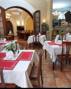 un restaurante con mesas con manteles rojos y blancos en Hotel Nais, en Durrës