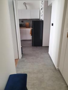 um corredor de uma cozinha com um frigorífico preto em Mirror Apartments em Oświęcim