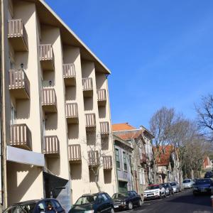 a building with balconies and cars parked on a street at Hotel Portofoz in Porto