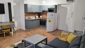 een keuken en een woonkamer met een bank en een tafel bij Pelso apartman in Keszthely