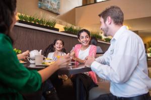 eine Gruppe von Menschen, die an einem Tisch in einem Restaurant sitzen in der Unterkunft Holiday Inn Indianapolis - Airport Area N, an IHG Hotel in Indianapolis