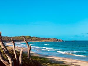 a beach with a bunch of waves in the ocean at Surf Beach Motel Coffs in Coffs Harbour