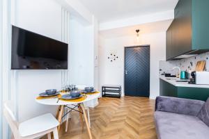 eine Küche und ein Wohnzimmer mit einem Tisch und Stühlen in der Unterkunft Apartamenty na Leśnej in Bukowina Tatrzańska