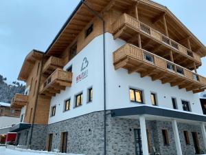 - un bâtiment avec des balcons en bois dans l'établissement Herz3 Hotel Bar Restaurant Trattoria, à Hollersbach im Pinzgau