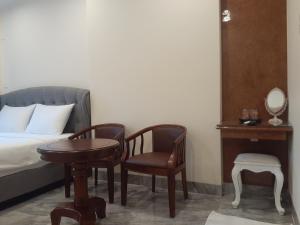 1 dormitorio con 1 cama, mesa y sillas en PEACE HOTEL, en Vung Tau