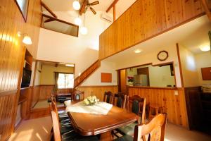 een eetkamer met een houten tafel en stoelen bij Lake Villa Kawaguchiko in Fujikawaguchiko