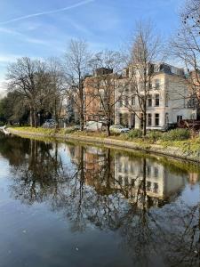 rzeka z drzewami i budynkami w mieście w obiekcie Spinoza Suites w Amsterdamie