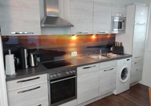 a kitchen with a sink and a stove top oven at Schwimmendes Ferienhaus Swimming Lounge in Kappeln