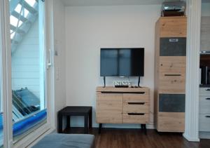 a bedroom with a tv and a dresser with a tvictericterictericter at Schwimmendes Ferienhaus Swimming Lounge in Kappeln