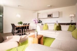 ein Wohnzimmer mit einem weißen Sofa und einem Tisch in der Unterkunft Tauernresidence Radstadt by ALPS RESORTS in Radstadt