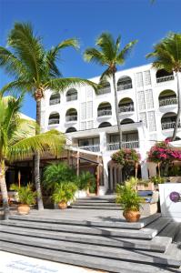 un edificio bianco con palme di fronte di Holland House Beach Hotel a Philipsburg