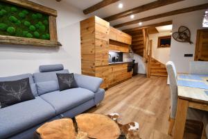 - un salon avec un canapé bleu et une table dans l'établissement Chalet Apartments Maštal, à Železná Ruda