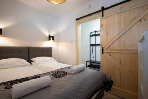 - une chambre avec un lit et une porte coulissante dans l'établissement TatryTop Apartamenty Alpejski SPA, à Kościelisko