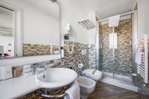 uma casa de banho branca com um lavatório e um WC em Borgo Aureo em Roma