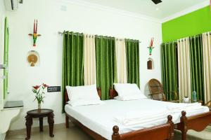 een slaapkamer met een bed met groene gordijnen bij Jasmin Villa in Cochin