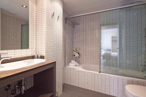 La salle de bains est pourvue d'une baignoire, d'un lavabo et de toilettes. dans l'établissement Hotel Acta Laumon, à Barcelone