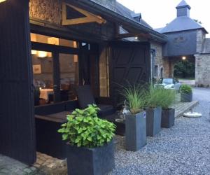 un groupe de plantes en pot devant un bâtiment dans l'établissement Orangerie de Blier à l'Affenage, à Érezée