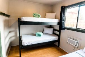 two bunk beds in a small room with a window at Garden of the Gods RV Resort in Colorado Springs